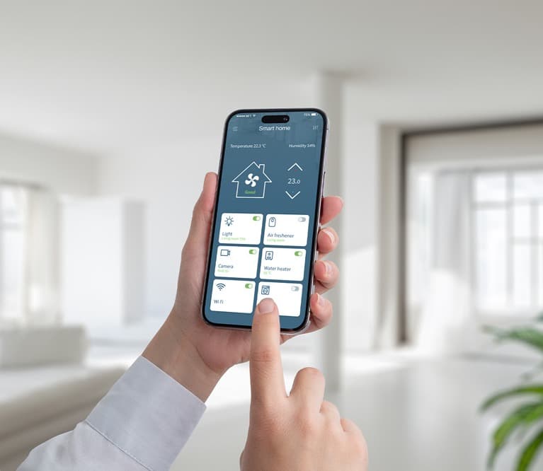 Hand bedient eine Smart-Home-App auf dem Smartphone in einem hellen Wohnraum