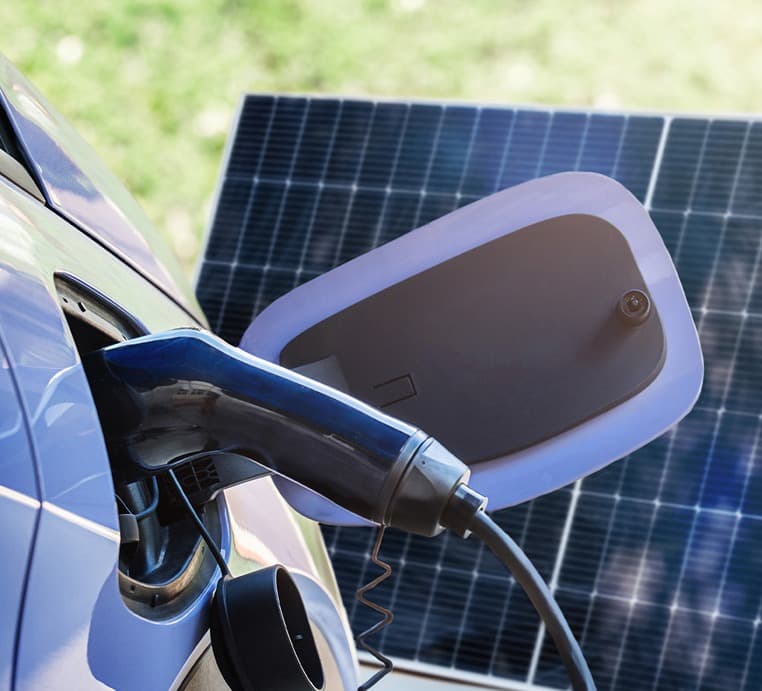 Elektroauto an einer Ladestation vor einem Solarmodul